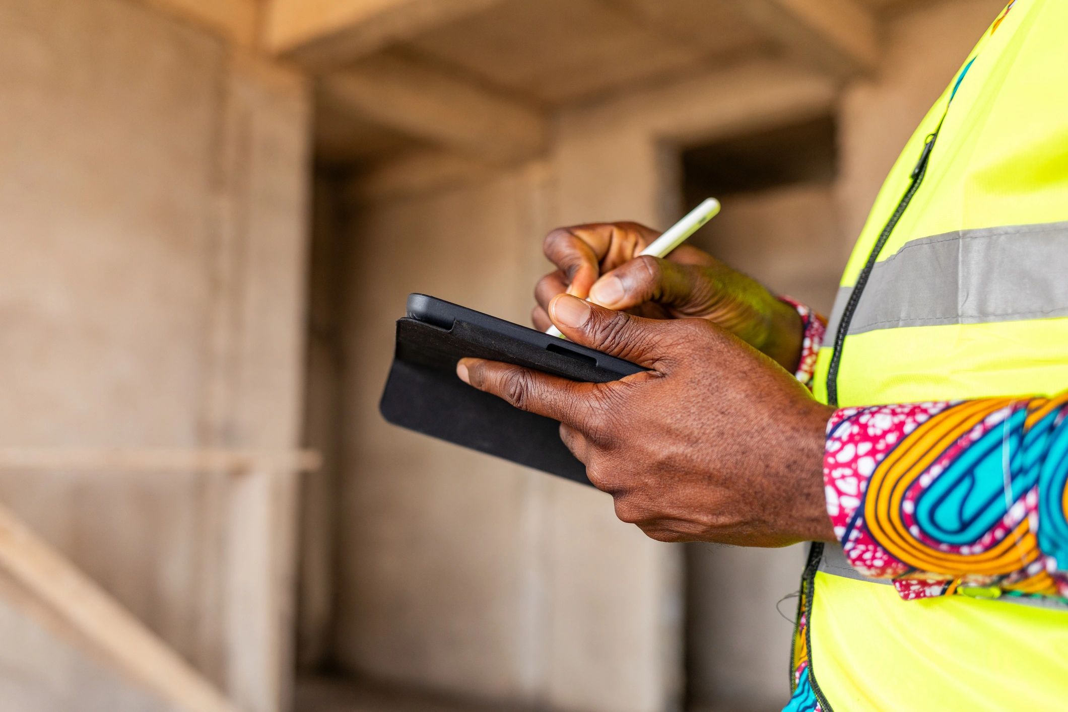 Construction engineer using a tablet at an active project site